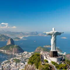 Der Corcovado mit der Christusstatue und der Zuckerhut (im Hintergrund) sind die Wahrzeichen von Rio de Janeiro