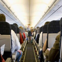 Stewardess und Passagiere in einem Flugzeug
